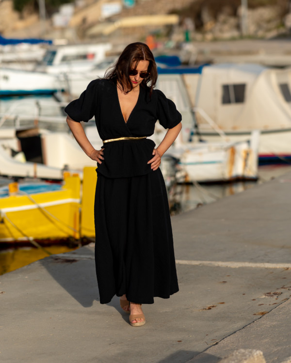 Žena v čiernom oblečení od Love Colors pózuje v prístave