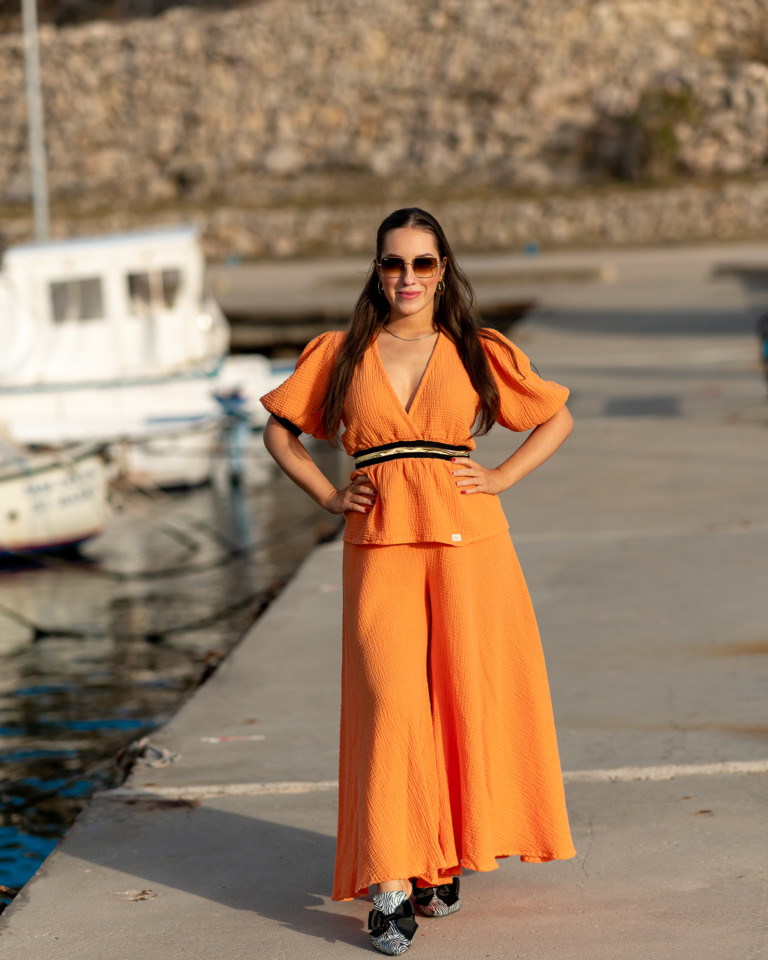 Žena v oranžovom oblečení od Love Colors pózuje v prístave