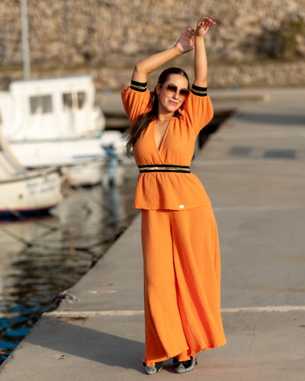 Žena v oranžovom oblečení od Love Colors pózuje v prístave