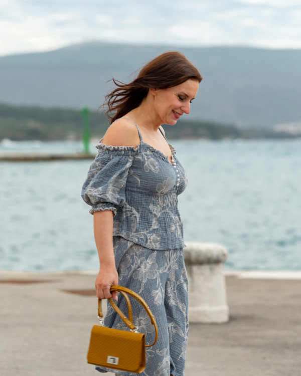 Žena v kvetinovom modrom oblečení od Love Colors kráča v prístave