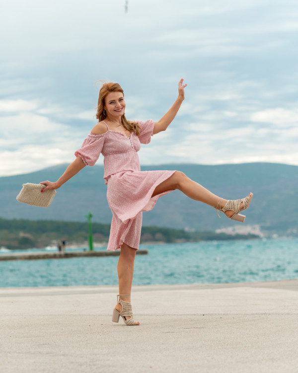 Žena v bodkovanom ružovom oblečení od Love Colors kráča v prístave