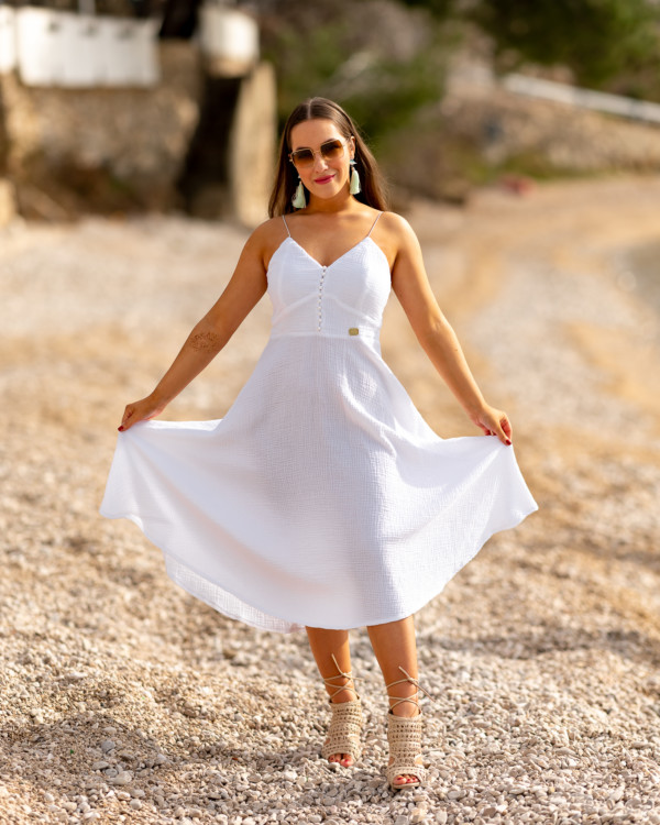 Žena v bielych mušelínových šatách od Love Colors pózuje pri mori