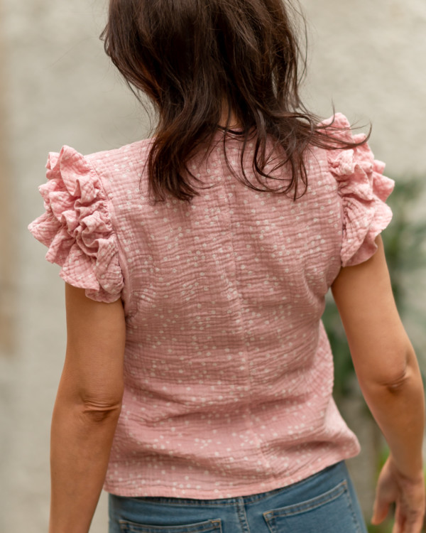 Žena v ružovom tričku s volánikmi na ramenach