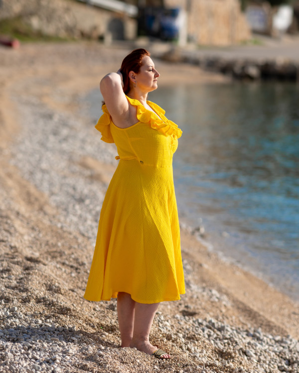 Žena v žltých šatách od Love Colors pri mori