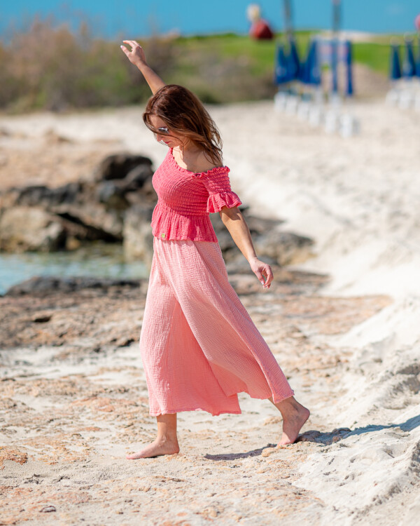 Žena na pláži v mušelínovom outfite