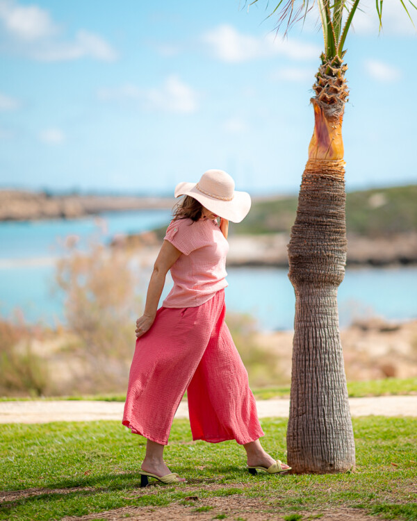 Žena na pláži v mušelínovom outfite